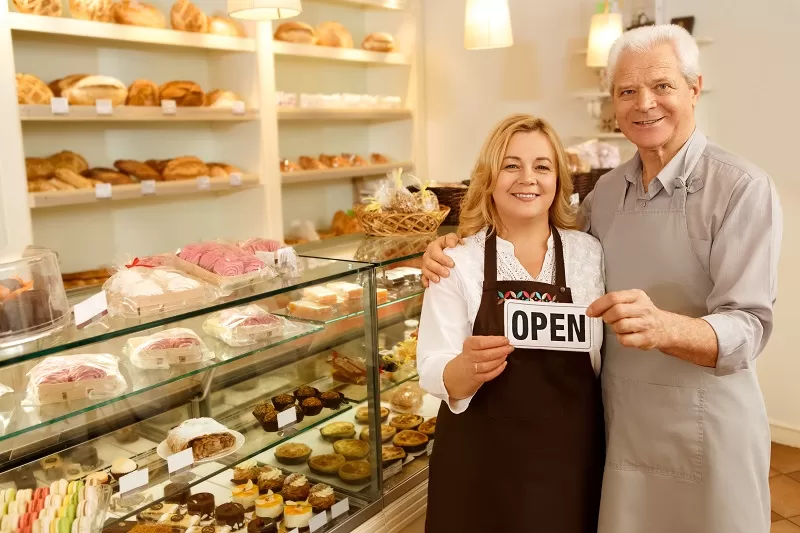 Panadería con dos personas con el cartel «OPEN»